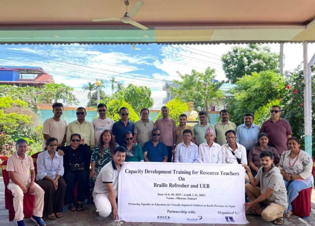 Group photo together 26 all trainers and participants with banner.