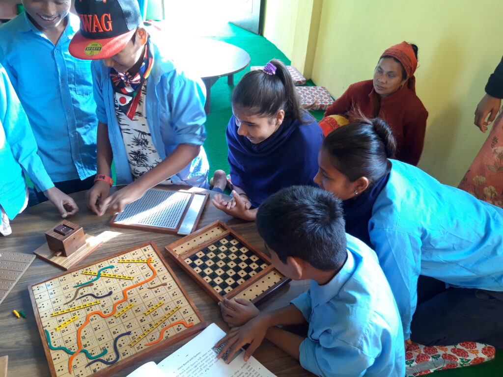 School Blind children are learning snakes and ladder and chess
